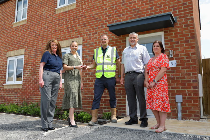 Five people outside a new build home