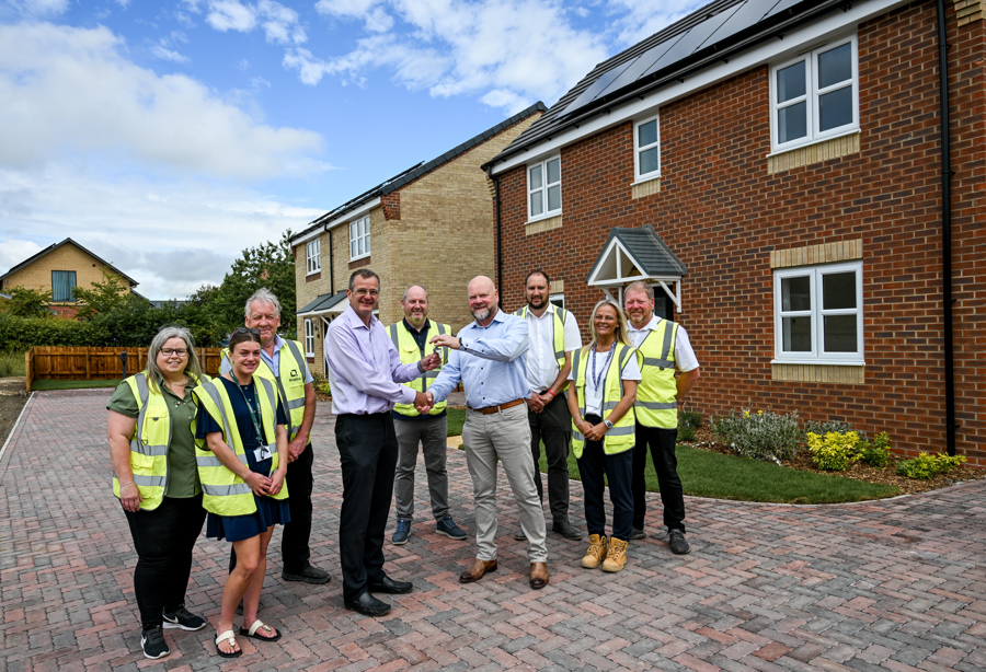 Group of people standing outside new build
